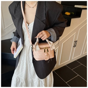 Sac à main rose avec poignée enroulée d'un foulard et détails dorés élégants