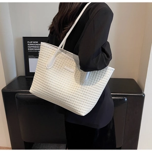Detailed view of woven texture and premium leather strap on the white tote bag