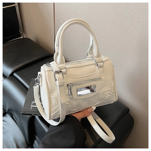 Primer plano del bolso Boston blanco crema con placa de plata Lazy Breeze y textura de cuero
