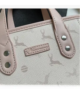 Close-up of lychee grain leather bucket bag with deer print and pink purple trim detailing