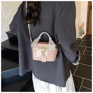 Détail du sac boîte en cuir rose avec poignée en foulard décoratif et bandoulière