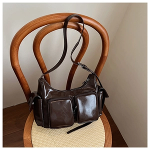 Detail of dark brown vintage faux leather shoulder bag with multiple front zip pockets