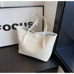 Detail of white woven tote bag texture with slim straps on dark wooden surface
