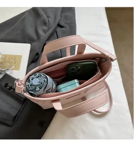 Top view of pink bucket bag interior showing capacity with phone, wallet and umbrella