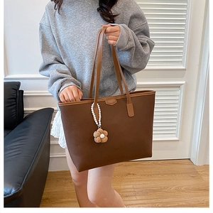 Vue détaillée du sac cabas marron en similicuir grainé avec pendentif fleur en perles