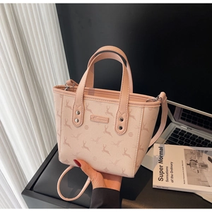 Détails du sac seau rose en cuir avec motif élan, doubles poignées et rivets métalliques