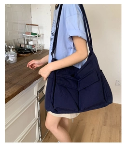 Side view of large navy blue canvas tote bag with functional utility pockets