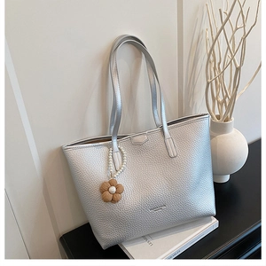 Détail du sac cabas en similicuir argenté grainé avec breloques fleurs et perles