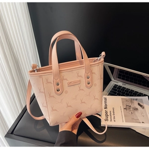 Détails du sac seau rose avec imprimé cerf et texture en cuir grainé sur le bureau