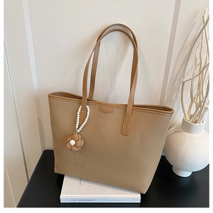 Détail du sac cabas kaki grainé avec breloque fleur en perles et longues anses