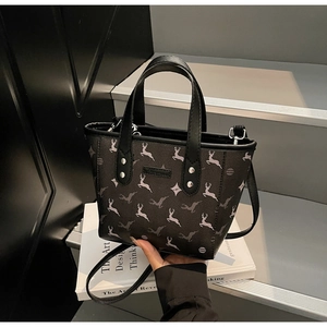 Gros plan du sac seau noir avec motifs de cerf et détails de rivets métalliques