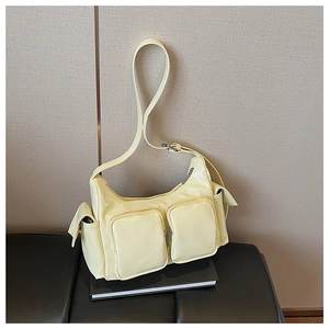 Detailed shot of cream yellow patent leather shoulder bag with glossy finish and pockets