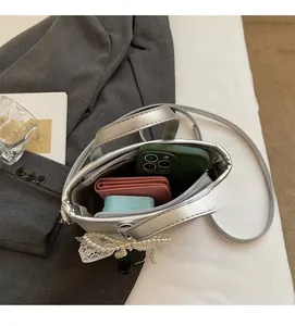 Interior view of silver bucket bag showing capacity for phone, wallet and earphones