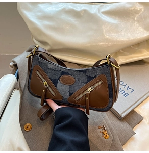Detail of vintage Y2K baguette bag featuring blue denim and brown leather patchwork