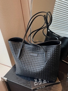 Large black woven leather tote bag with long shoulder straps for daily business commute