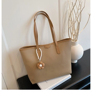 Détail du sac cabas en cuir grainé kaki avec accessoire pendentif fleur et perles blanc