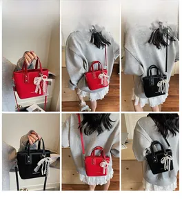 Detail shot of mini bucket bags in red and black with elegant lace pearl pendants