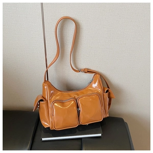Detailed view of caramel glossy faux leather shoulder bag with multiple functional pockets