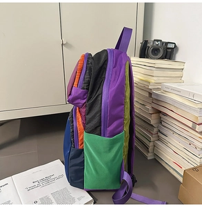 Detail of multi-color patchwork backpack with green mesh side pocket and zipper design