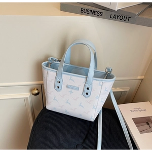 Détail du sac cabas bleu clair à motif de renne avec doubles poignées et ferrures