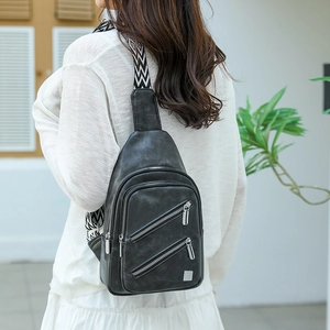 Back view of black faux leather chest bag featuring geometric pattern wide strap