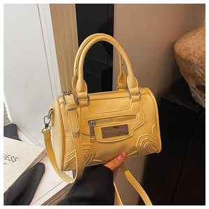 Detalle de un bolso Boston amarillo de cuero PU con placa de logo metálica Lazy Breeze