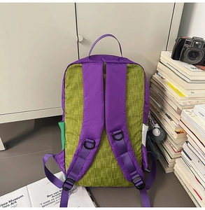 Detail view of purple patchwork backpack showing padded mesh back and adjustable straps