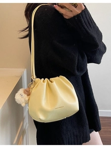 Light yellow pleated bucket bag with long strap and cute plush lamb pendant