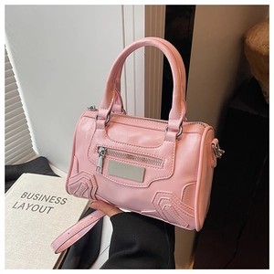 Detalle del bolso Boston rosa con textura de cuero premium y correa de hombro ajustable