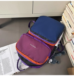 Detail of multi-color nylon backpack with various zip pockets and mesh side compartments