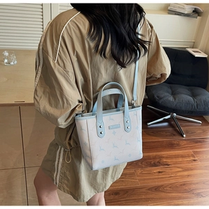 Détail du petit sac seau avec motif cerf et bandoulière réglable porté par le mannequin