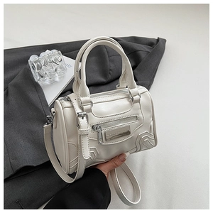 Detalle del bolso bandolera de cuero blanco con cremalleras y asas redondeadas