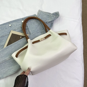 Detail of cream white pebbled leather tote bag with brown straps and golden twist lock