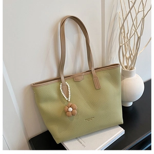 Détail du sac cabas en cuir à motif litchi vert haricot avec pendentif fleur en perles