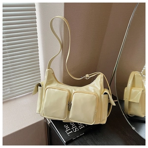 Macro detail of glossy yellow patent leather shoulder bag with zipper pocket and silver hardware
