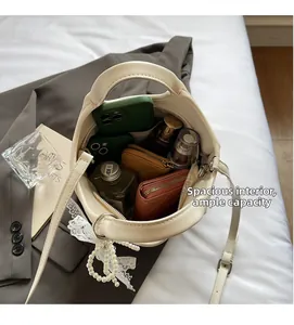 Detail showing the large capacity of the beige bucket bag with various personal items