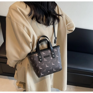 Detail of printed bucket bag with deer pattern and adjustable strap on a model