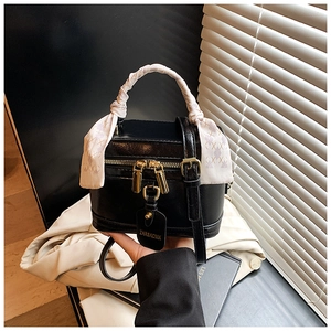 Vue détaillée d'un sac à main boîte noir avec poignée en foulard et fermeture éclair dorée