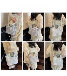Detail view of light blue gingham bucket bag with lace edges and pearl pendant charms