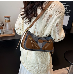 Detail of vintage baguette bag featuring brown leather and gray denim patchwork texture