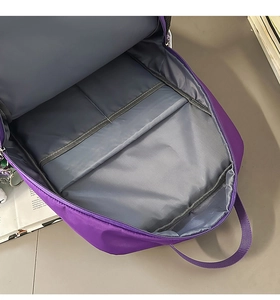 Interior view of purple nylon backpack showing the padded laptop compartment and storage space