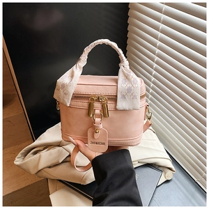Close-up of pink box bag with lychee grain texture and floral scarf wrapped handle