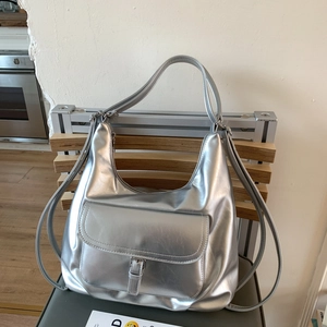 Detail der silbernen Metallic-Tasche mit verstellbaren Riemen als Schultertasche oder Rucksack