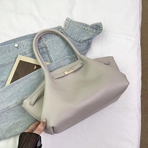 Detail view of the elegant textured leather surface and gold twist lock on the shoulder bag