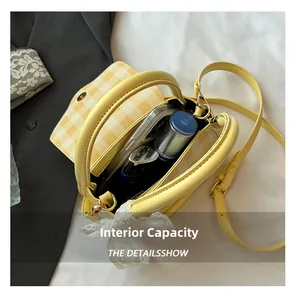 Detail view of large capacity interior for yellow checkered crossbody bag with phone pocket
