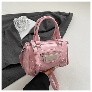 Detalle del bolso Boston de cuero PU rosa con placa metálica y correa de hombro extraíble