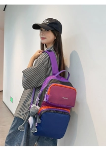 Detail view of the durable nylon backpack side featuring a grey plush doll charm accessory