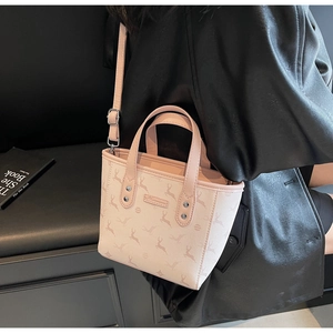 Détail du sac cabas rose avec motif cerf et finitions argentées sur veste en cuir