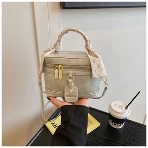 Détail du sac à main gris avec poignée en foulard de soie et ornements dorés