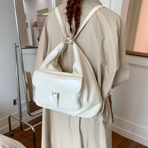 Detail eines cremeweißen Hobo-Rucksacks mit großem Fassungsvermögen und silberner Metallschnalle